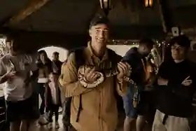 Dan Case holding a large snake during travel