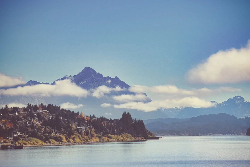Clouds crossing a mountain above a quiet lake