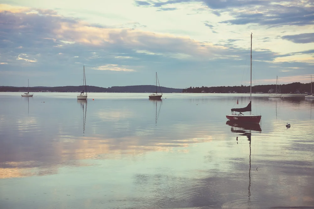 Sailboats resting on calm water at dusk