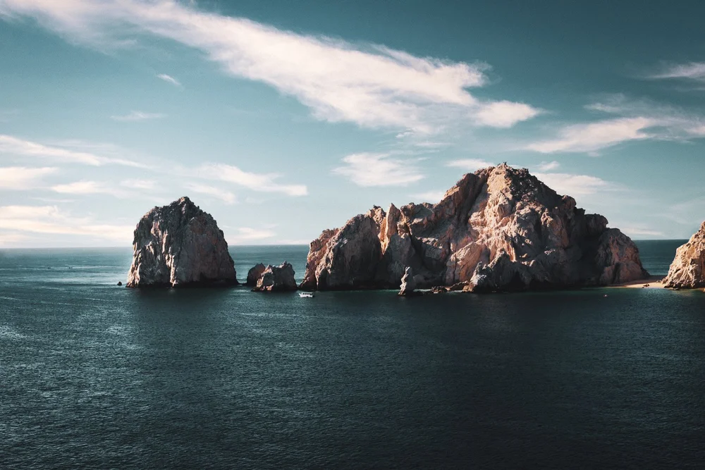 Rock formations rising from deep blue ocean water