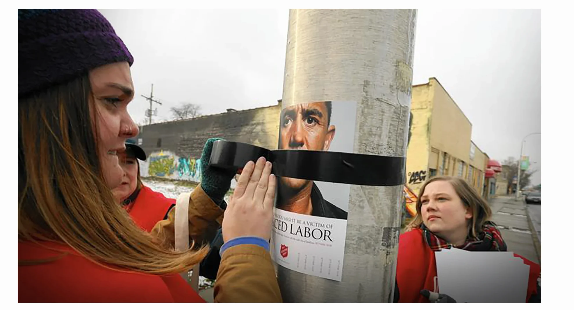 Volunteers installing a Salvation Army forced-labor awareness poster